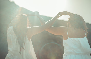 Chicas vestidas de blanco disfrutando en un bonito paisaje de la playa
