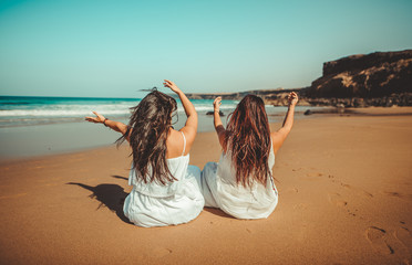 Chicas vestidas de blanco disfrutando en un bonito paisaje de la playa