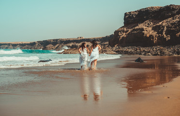 Chicas vestidas de blanco disfrutando en un bonito paisaje de la playa
