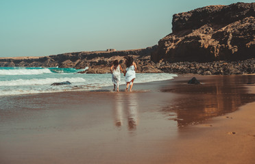Chicas vestidas de blanco disfrutando en un bonito paisaje de la playa