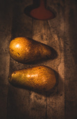 Pera en un fondo de madera  y rodeada por granos de café