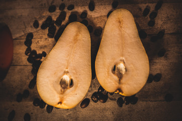 Pera en un fondo de madera  y rodeada por granos de café