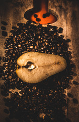 Pera en un fondo de madera  y rodeada por granos de café