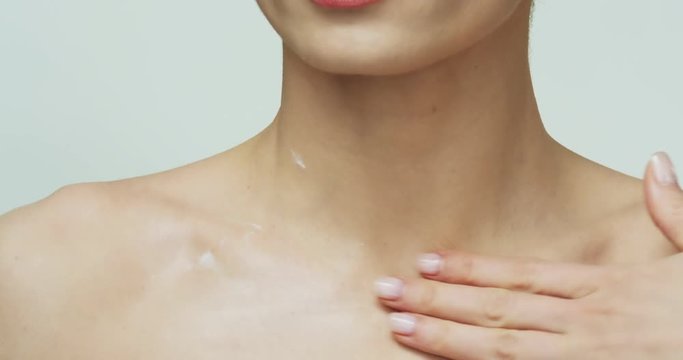 Close up of the female Caucasian hand massaging and caressing her shoulders and neck on the white background. Health and beauty care.