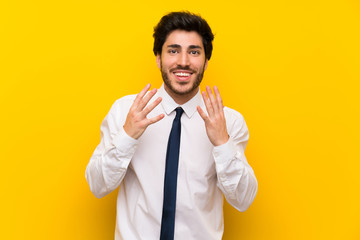 Businessman on isolated yellow background with surprise facial expression