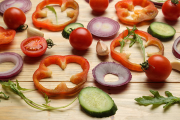 Ingredients for cooking salad. background from Various vegetables and spices carrot, tomato, onion, cucumber, pepper and arugula on a brown wooden table.