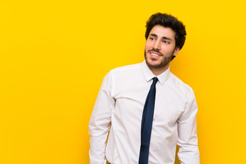 Businessman on isolated yellow background laughing