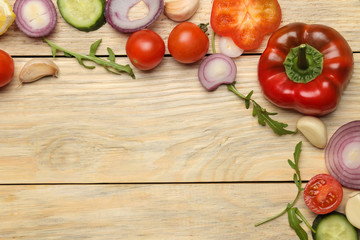 Ingredients for cooking salad. frame of Various vegetables and spices carrot, tomato, onion, cucumber, pepper and arugula on a natural wooden table. top view.