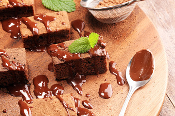 Brownie dessert. Cake chocolate brownies on wooden background with mint.