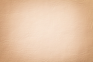 Light coral leather texture background, closeup. Beige cracked backdrop