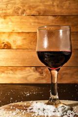 Glass of iced red wine in a rustic setting.