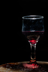Glass of iced red wine in a rustic setting.