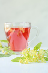 linden flowers with a brewed linden tea in the background