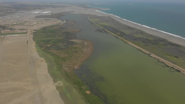 Pullback and panoramic  aerial view of Albufera de medio mundo wetlands in Huacho Peru.