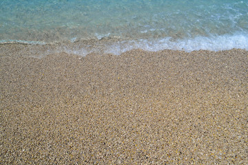 Fototapeta na wymiar Sea wave on the shore of a pebble beach, water, foam, background