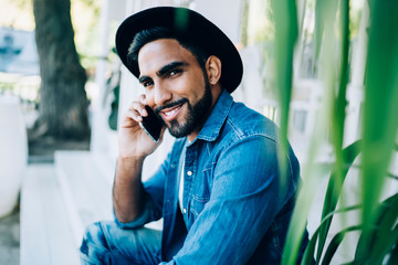 Close up portrait of handsome hipster guy dressed in stylish outfit looking at camera while making...