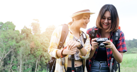 Asian Group of young people Hiking with friends backpacks walking together and looking map and taking photo camera by the road and looking happy ,Relax time on holiday concept travel