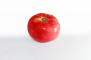 Red tomatoes with water drops on the white with reflection