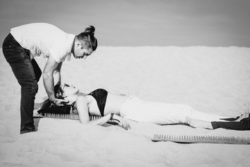 extreme yoga training - relaxation and self-development - man trainer (master) helping beautiful...