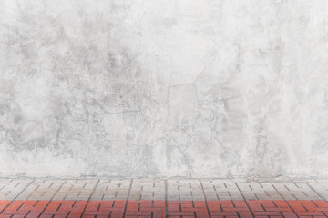 Empty grey concrete wall with bricks floor in room. Abstract background or backdrop.
