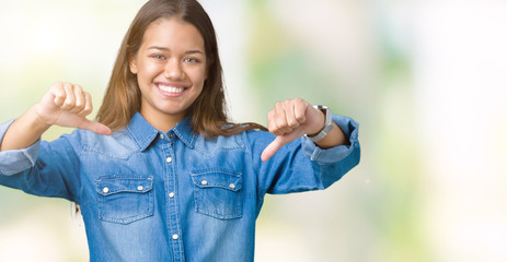 Young beautiful brunette woman wearing blue denim shirt over isolated background looking confident...