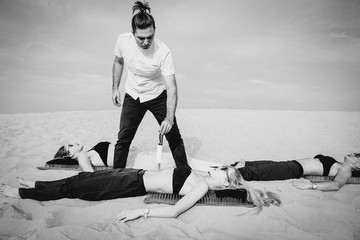 Extreme training - man (guru, master) keep knife on woman's stomach outdoor in desert. Extreme...