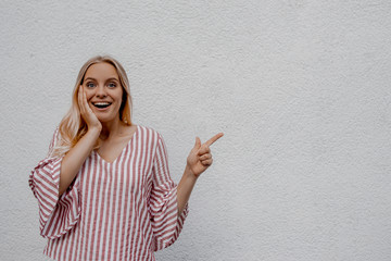 Surprised female elegant lady, keeps mouth opened, being stupefied as advertises something, wears...
