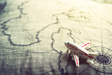 Travel and transportation background concept. Airplane model on retro map with sunlight in vintage...