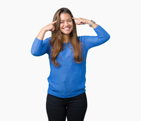 Obraz na płótnie Canvas Young beautiful brunette woman wearing blue sweater over isolated background Smiling pointing to head with both hands finger, great idea or thought, good memory