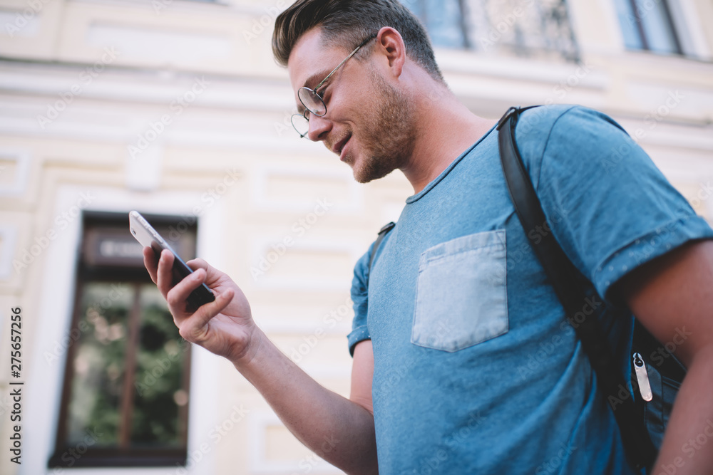 Aufkleber positive millennial hipster guy checking mail and messages on smartphone searching number of online 
