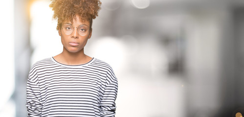 Beautiful young african american woman wearing glasses over isolated background Relaxed with serious expression on face. Simple and natural looking at the camera.