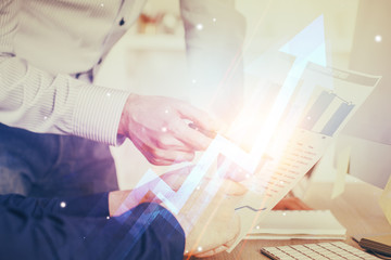 Fototapeta premium Businessman with creative business upward arrows on people hands background. Financial growth concept. Double exposure