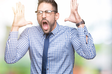 Young business man wearing glasses over isolated background celebrating mad and crazy for success...