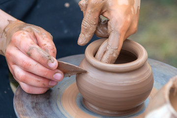 Potter's hands making clay pot.