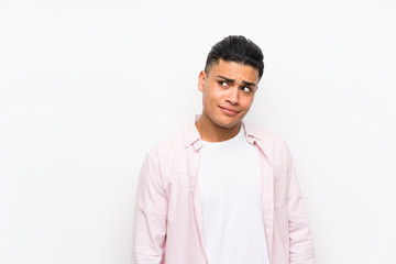 Young man over isolated white wall standing and looking to the side