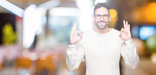 Young handsome man wearing glasses over isolated background relax and smiling with eyes closed doing meditation gesture with fingers. Yoga concept.
