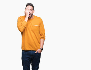 Young handsome man over isolated background covering one eye with hand with confident smile on face and surprise emotion.