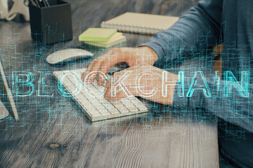 Crypto currency theme hologram with businessman working on computer on background. Concept of...