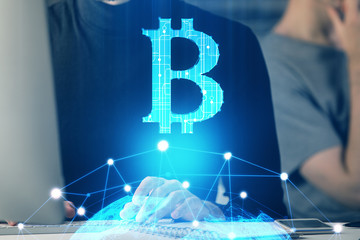 Crypto currency theme hologram with businessman working on computer on background. Concept of...