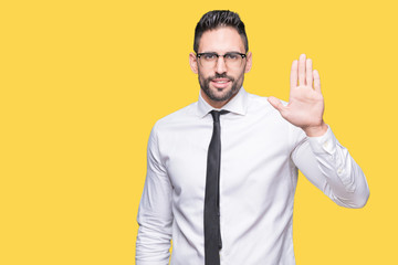 Young handsome business man wearing glasses over isolated background Waiving saying hello happy and smiling, friendly welcome gesture