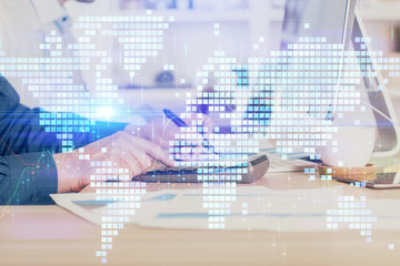 Fototapeta premium Double exposure of businessman working on laptop on background. International business hologram in front. Concept of success.