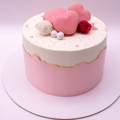 Delicate pink cake decorated with hearts and berries. On a white background.