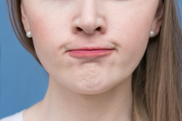 Grimace of irritation or discontent on the face of a  beautiful woman, purses lips, close up