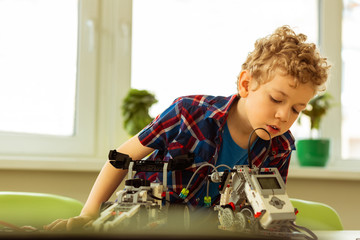 Nice young boy being interested in robotics
