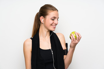 Young sport woman over isolated white background with an apple
