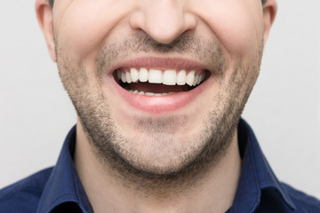 Obraz premium Emotions on the face of a young bearded man, mouth detail with laughing expression, close up, the concept of human emotion