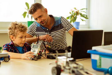 Pleasant bearded man sitting with his student