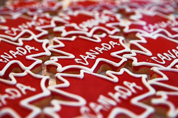 Gingerbread in the form of red, maple leaves, marked Canadian. in the window of the candy store. Selective focus.