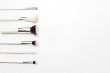 Set of makeup brushes, white background, copy space, advertising, slogan, text, top view