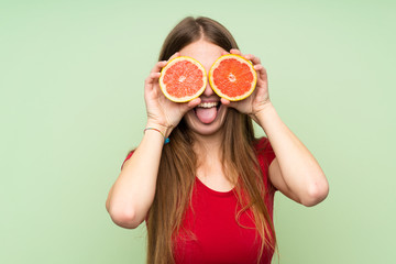 Young woman with long hair wearing grapefruit slices as glasses